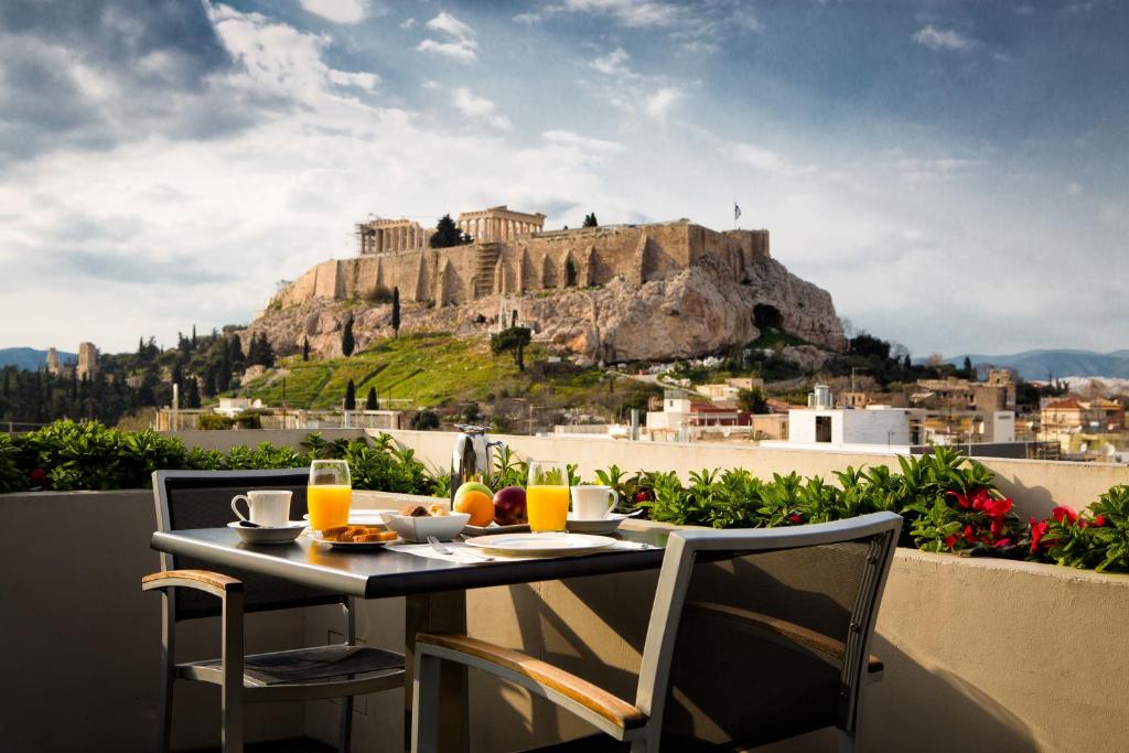 una mesa y sillas con vistas a la montaña en The Athens Gate Hotel en Athens