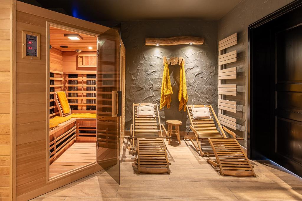 a room with chairs and a table and a wall at Einzigartige Traumwohnung mit Whirlpool & Sauna bietet Luxus und Erholung in Neuheilenbach