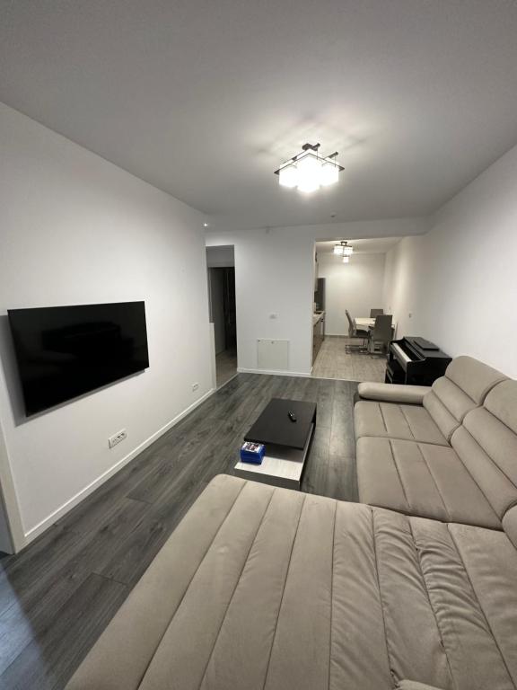 a living room with a couch and a flat screen tv at Apartament Anastasia Residence in Oradea