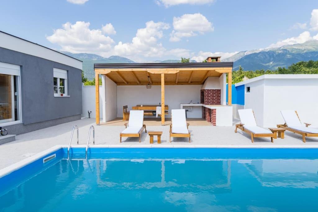 eine Terrasse mit Pool und ein Haus in der Unterkunft Vila Nur Mostar in Mostar