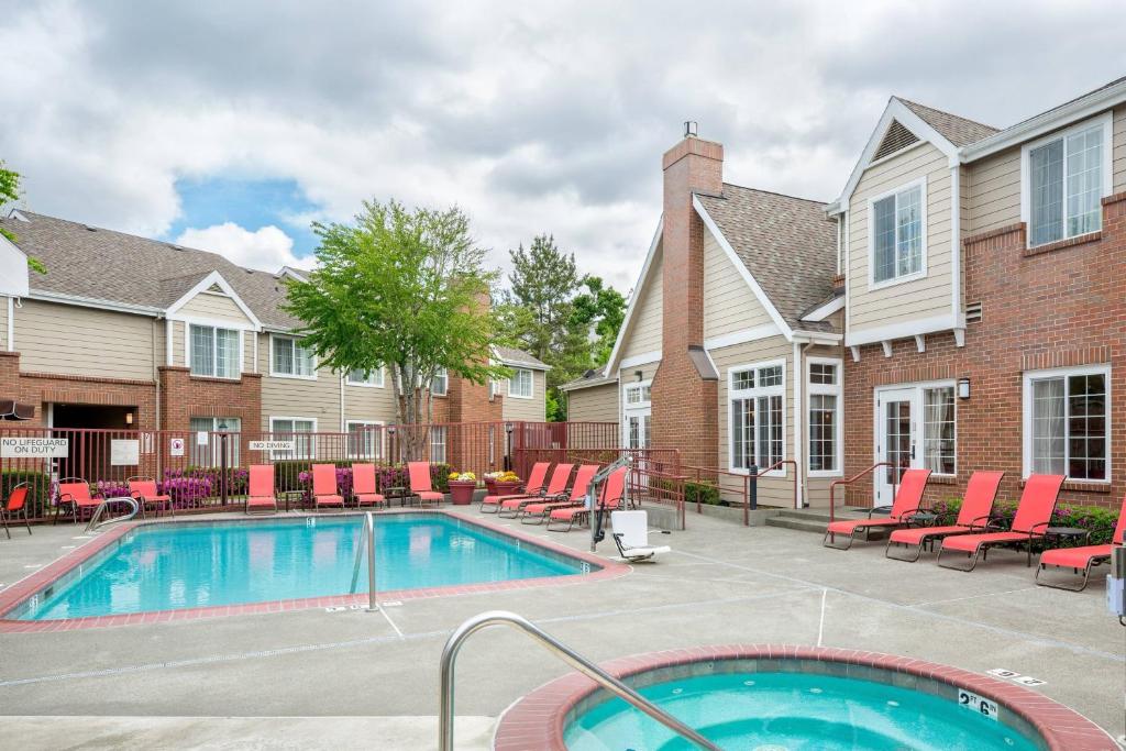 uma piscina num pátio com cadeiras e uma casa em Residence Inn Portland Hillsboro em Hillsboro
