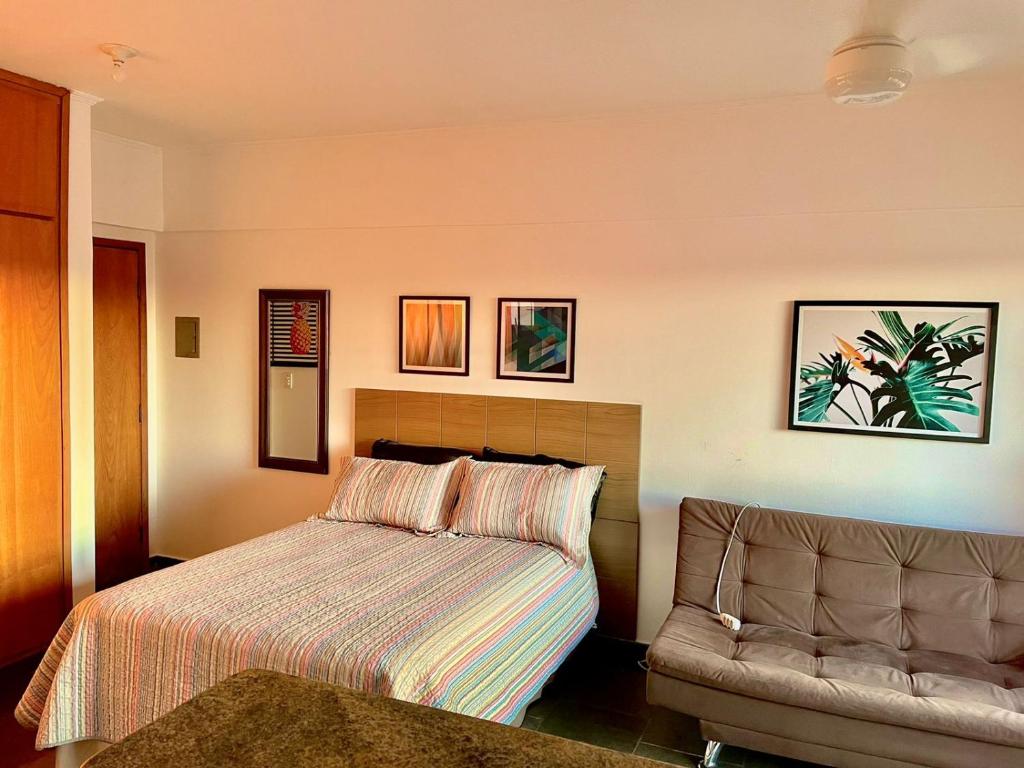 a hotel room with a bed and a couch at Ravena 016 in Ribeirão Preto