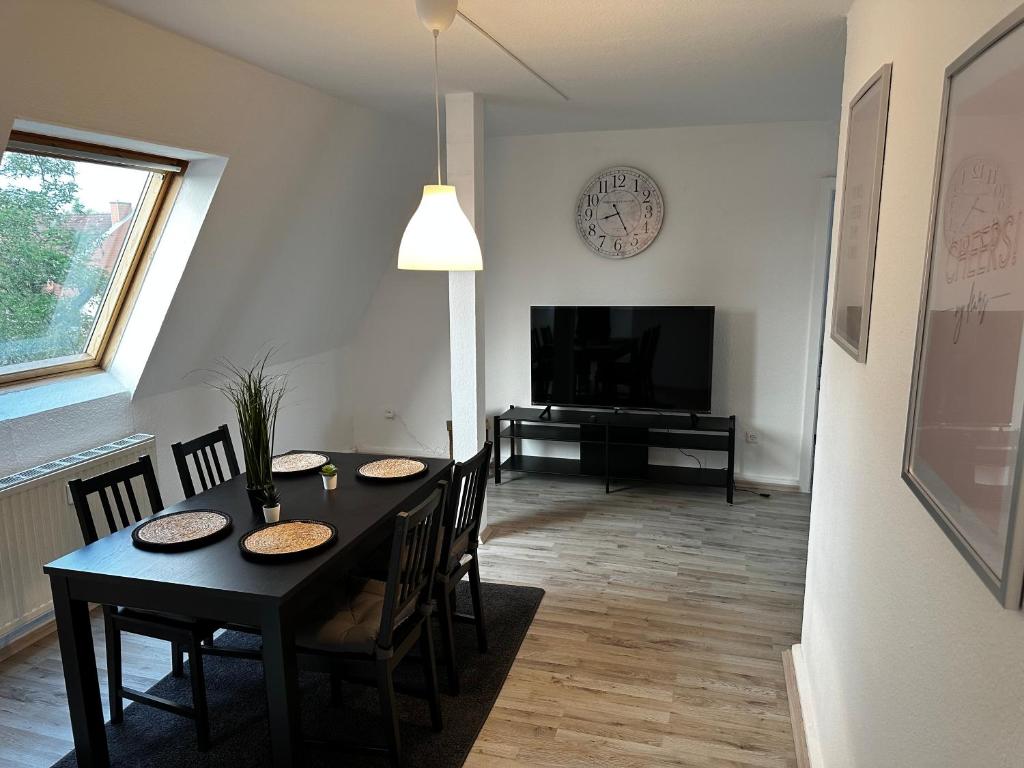 a dining room with a table with chairs and a television at A&V Apartments Schöne Dachgeschoss Wohnung Apt Sterne in Gelsenkirchen