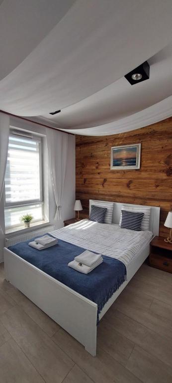グディニャにあるApartament Marco Polo Oneのベッドルーム1室(大型ベッド1台、タオル2枚付)