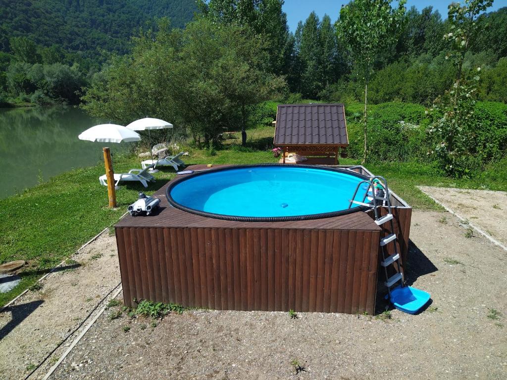 a swimming pool with an umbrella and a swimming pool at Vikendica Mihic in Zvornik