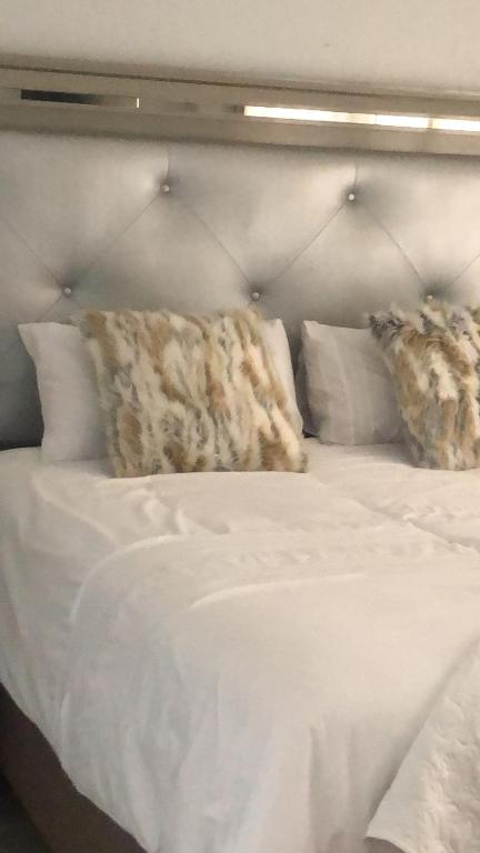 białe łóżko z białą pościelą i poduszkami w obiekcie Emabheni Self Catering w mieście Langstrand