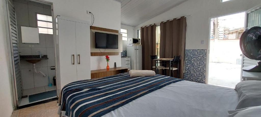 um quarto com uma cama e uma televisão na parede em Pousada Aconchego Ocian na Praia Grande