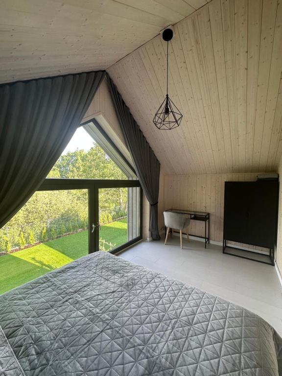 a bedroom with a bed and a tv and a window at Stodoły na Fali in Sławoszynko