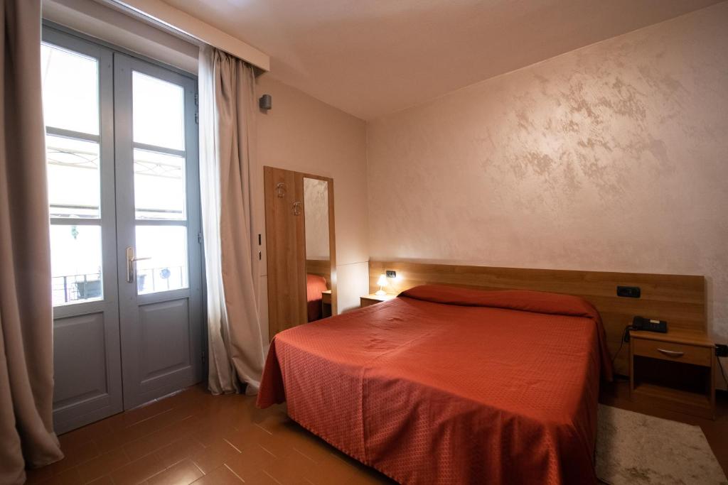um quarto com uma cama e uma grande janela em Alessi Appartamenti em Desenzano del Garda