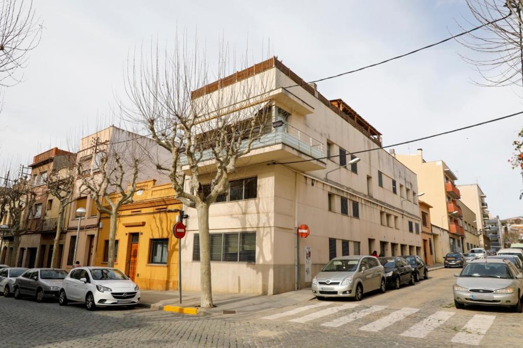 a building on a street with cars parked in front at Mazi Apartments Martinet in Mataró