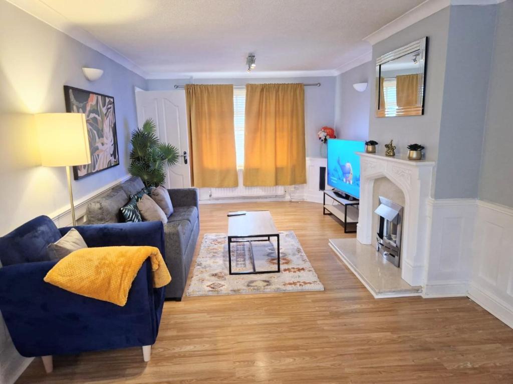 uma sala de estar com um sofá azul e uma lareira em Sigma Palace em Longbenton
