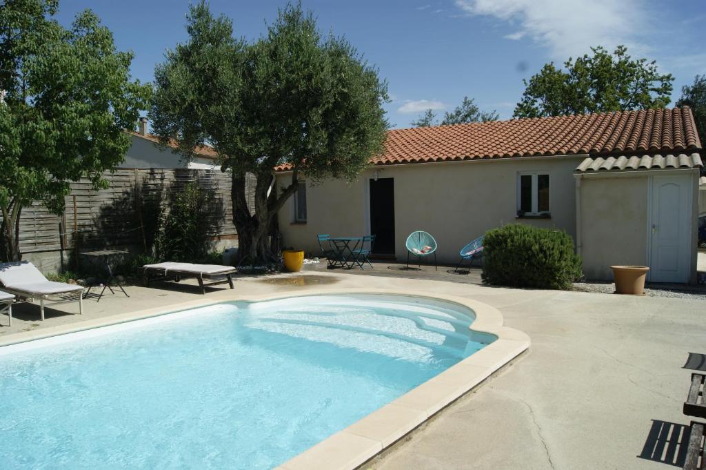 una piscina en un patio con una casa en Studio avec piscine, en Corbère
