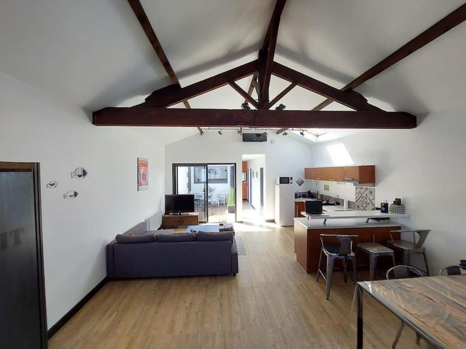 un salon avec un canapé et une cuisine dans l'établissement Maison ambiance loft à 2 pas du port d'Arcachon et des plages, à Arcachon