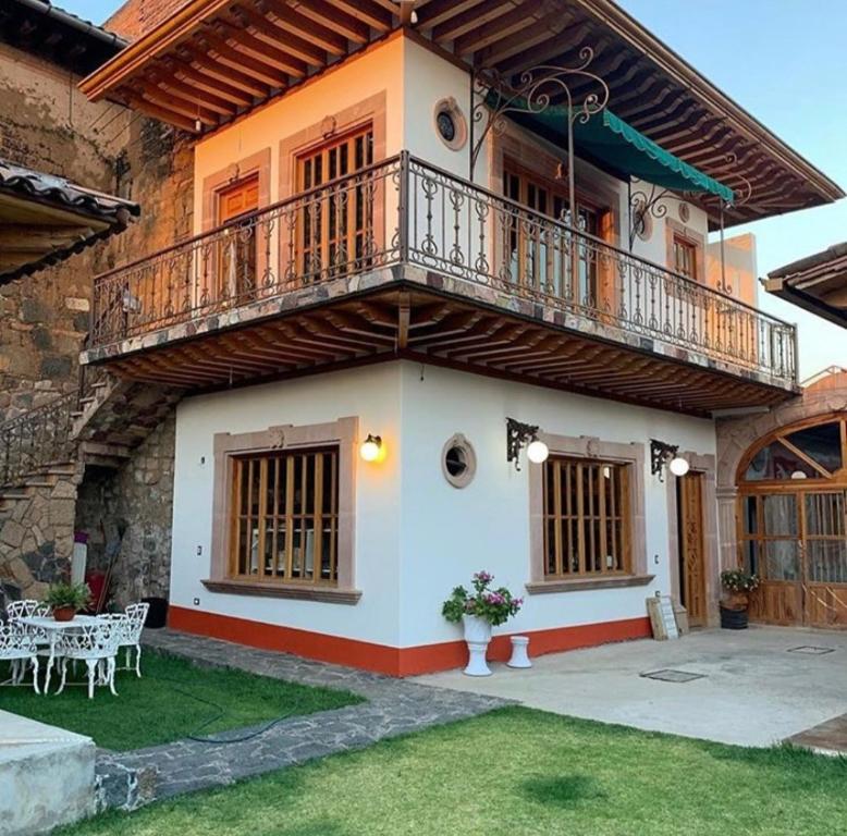 a house with a balcony on top of it at La Casa Baez in Pátzcuaro