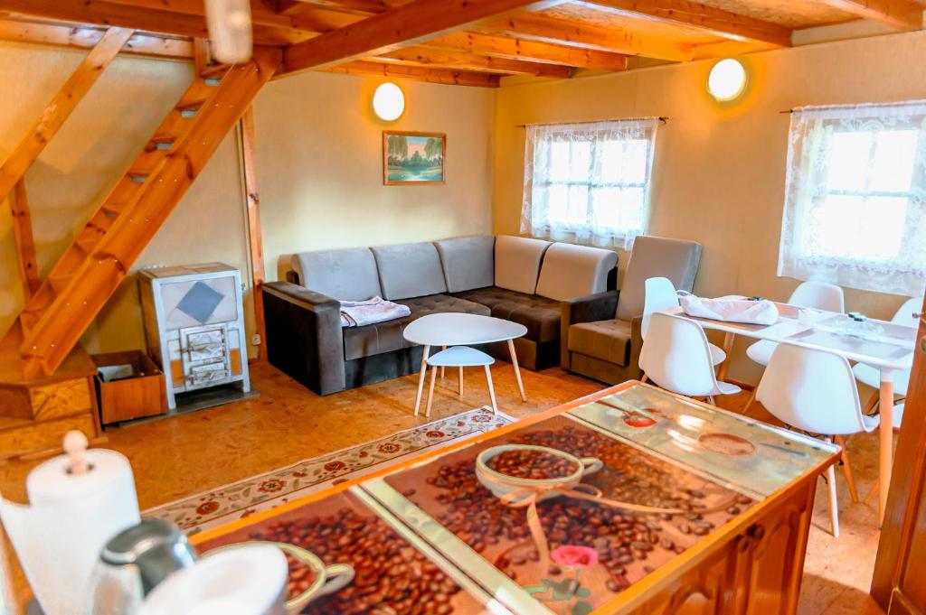 ein Wohnzimmer mit einem Sofa und einem Tisch in der Unterkunft Domek na Mazurach 