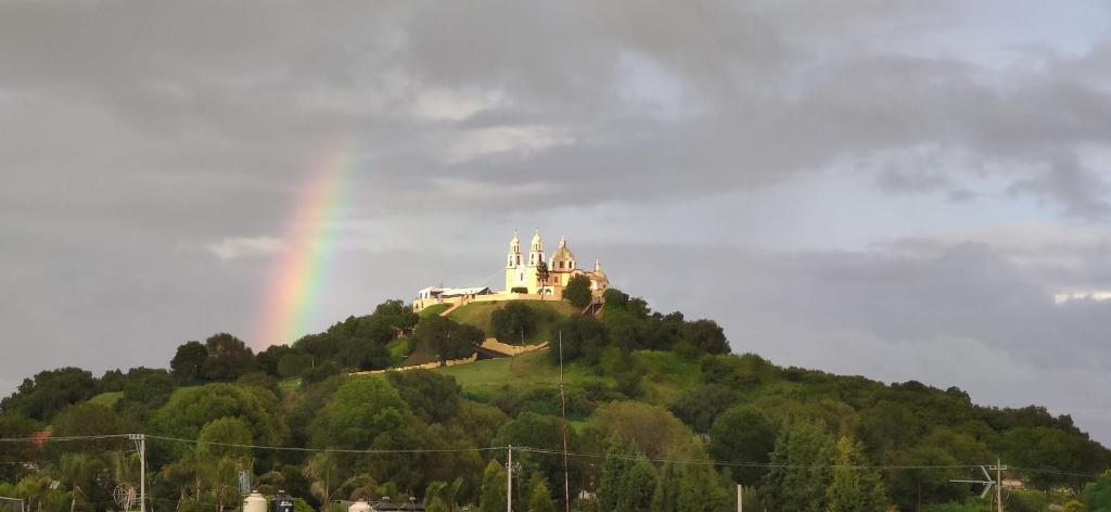 a rainbow over a castle on top of a hill at Departamento Xolotl (Dios guía y del fuego) in Cholula