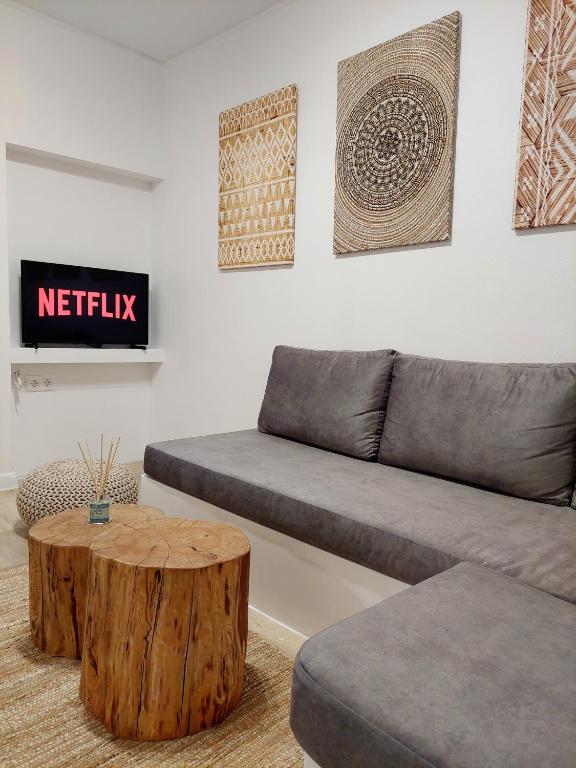 a living room with a couch and a tree stump coffee table at Josephine's place in Tinos
