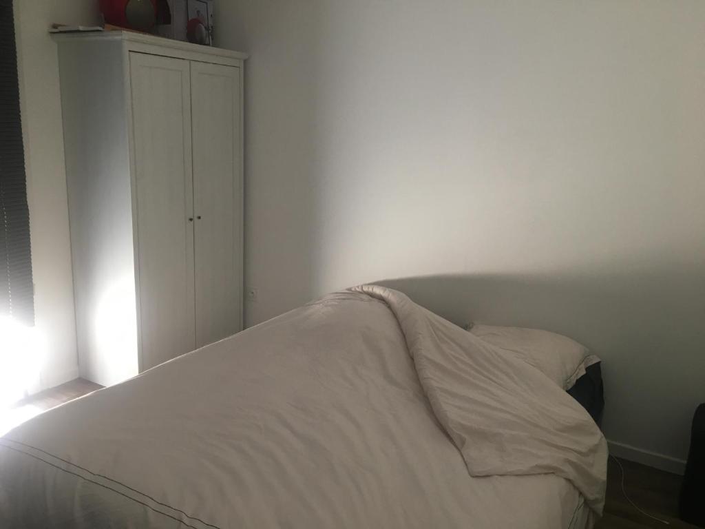 - une chambre avec un lit blanc et une armoire blanche dans l'établissement Jolie 2 pièces confortable, à Ballainvilliers
