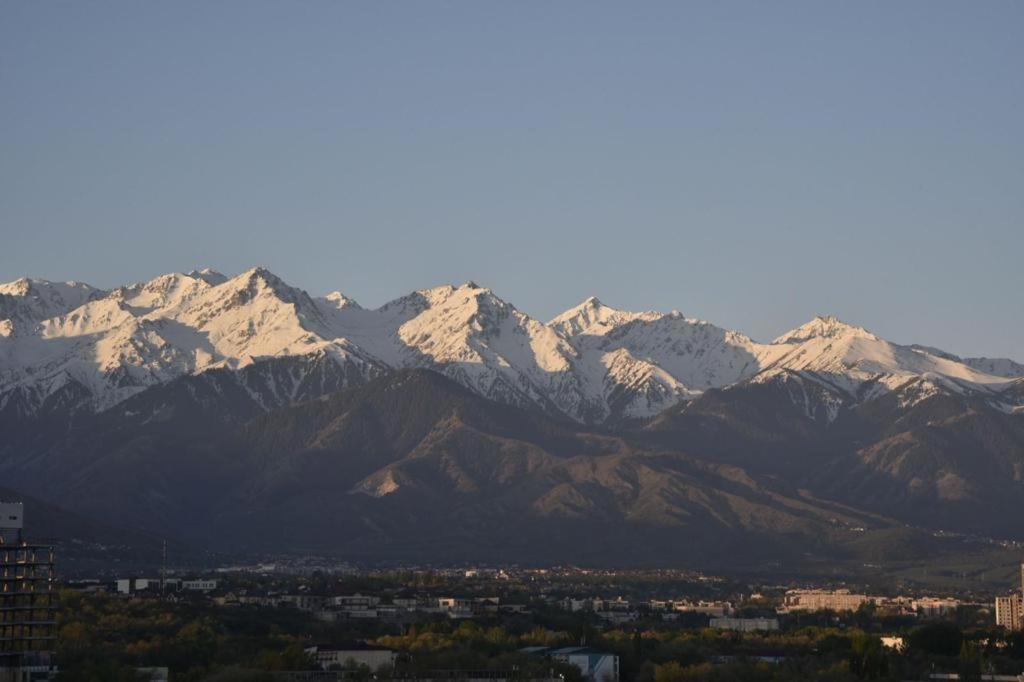 uma vista para uma serra com montanhas cobertas de neve em 2room apartment 100sq m With a Beautiful Mountain views em Almaty