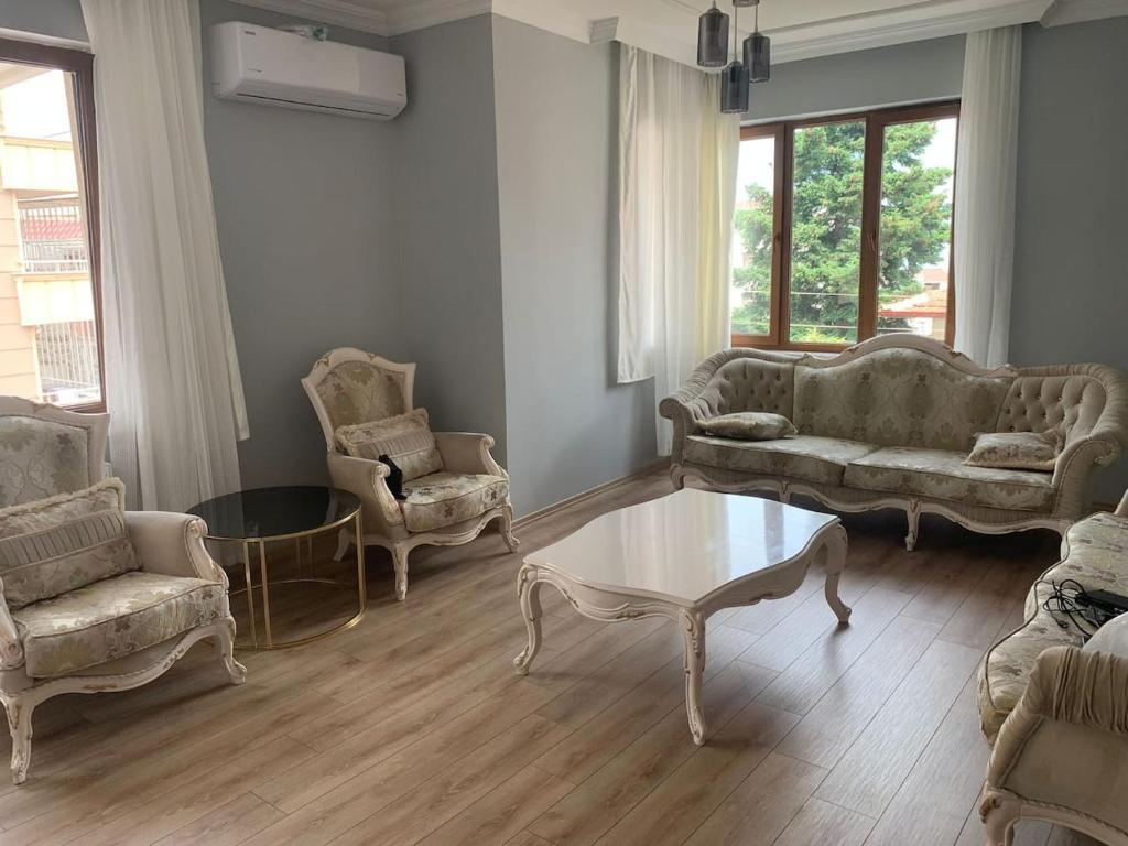a living room with couches and a table and chairs at Aydın Apart in Bostancı
