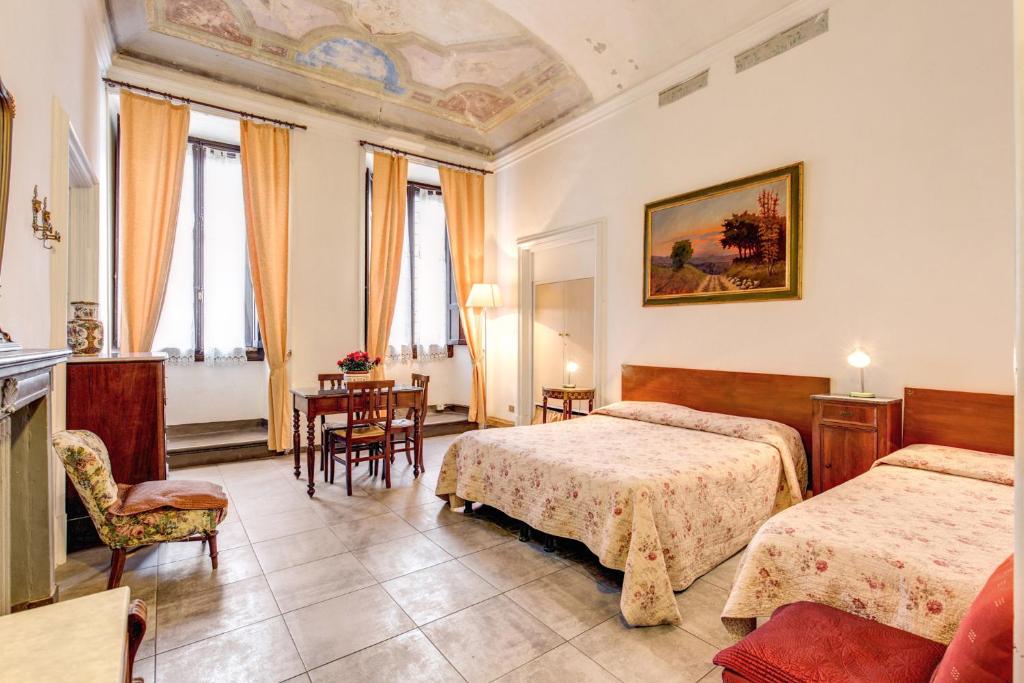una camera d'albergo con due letti e un tavolo di Albergo San Giovanni a Firenze