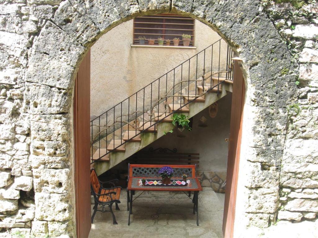 un arco en un edificio con una mesa y escaleras en Near the Duomo, en Erice