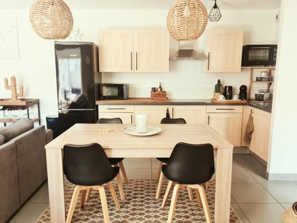 a kitchen with a wooden table and chairs at AppartCosy Emplacement Idéal avec Terrasse & Parking Privé in Nîmes