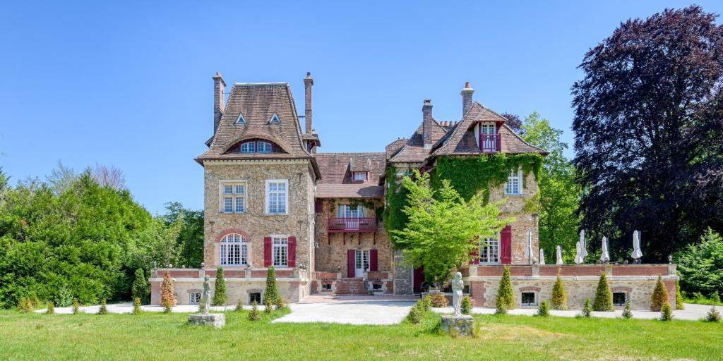 巴比松的住宿－Le Petit Château de Barbizon au Bois du Mée，一座在田野顶部有塔的老房子