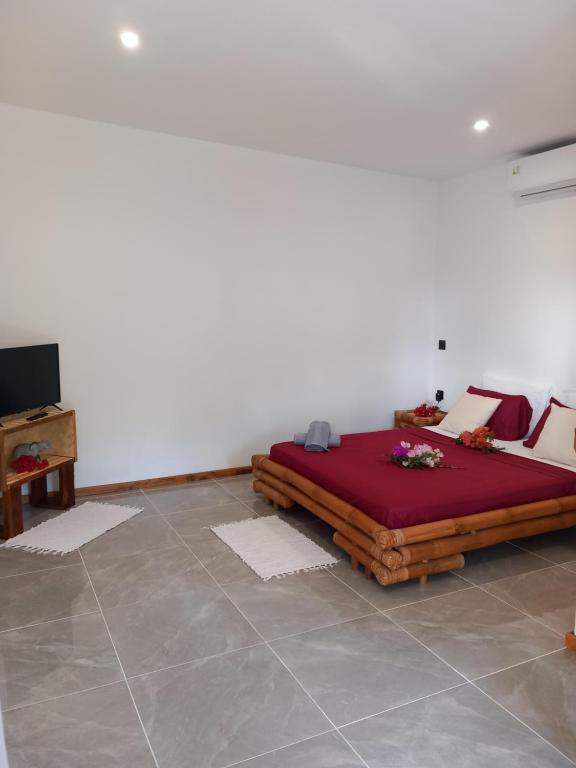 a bedroom with a large wooden bed in a room at Terei-Here Bungalow Airport in Avae