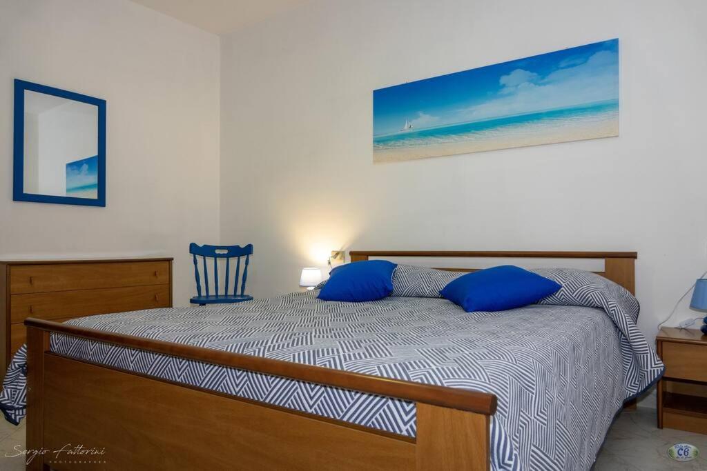 una camera da letto con un letto con cuscini blu di Cav la Ginestra vistamare Elba a Rio nellʼElba