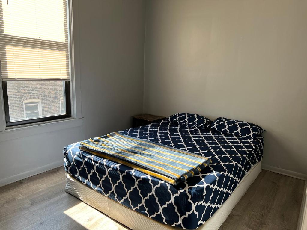 ein Schlafzimmer mit einem Bett in einem Zimmer mit einem Fenster in der Unterkunft Ethan 3 rooms in Chicago