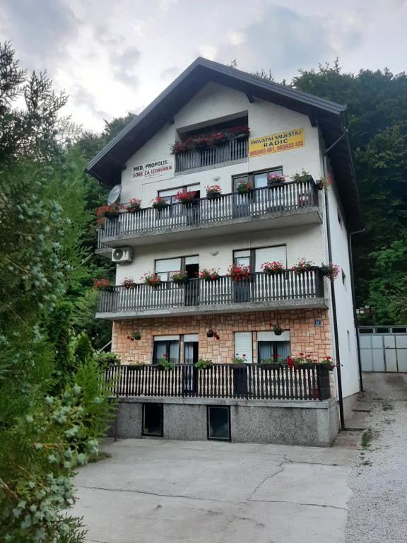 a large building with balconies and flowers on it at Privatni smještaj Radić in Teslić