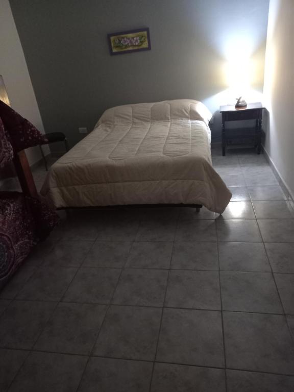 ein Schlafzimmer mit einem Bett und einem gefliesten Boden in der Unterkunft Don José in Villa Mercedes