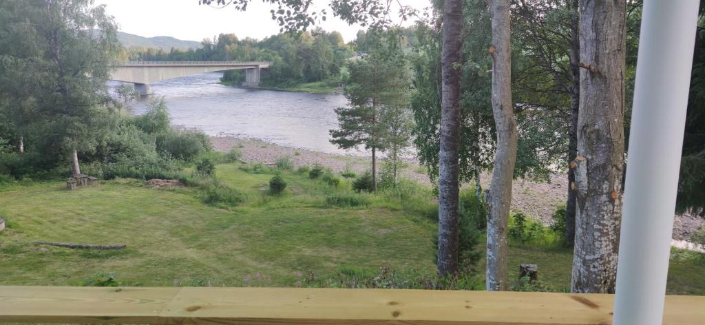 a view of a river with a bridge and trees at Relaxing home in Svarstad