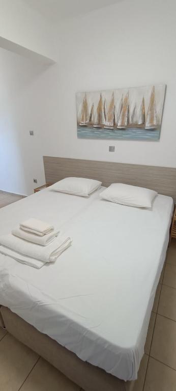 a white bed with white towels on top of it at Christinas 3 in Nerántza