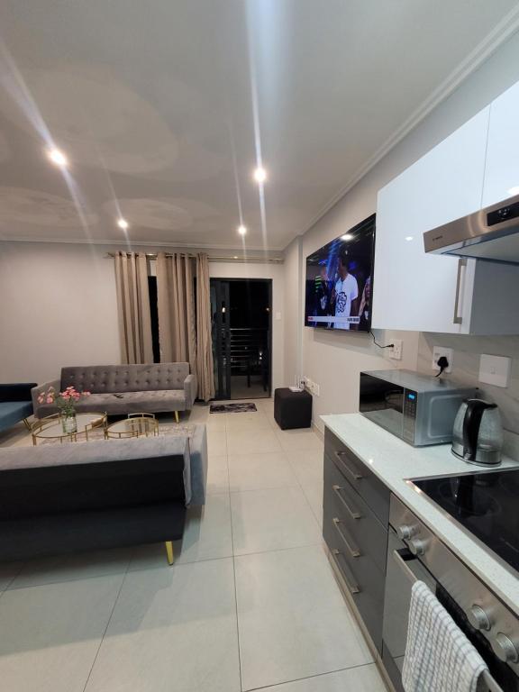 Two Bedroom Apartment في ديربان: مطبخ وغرفة معيشة مع أريكة