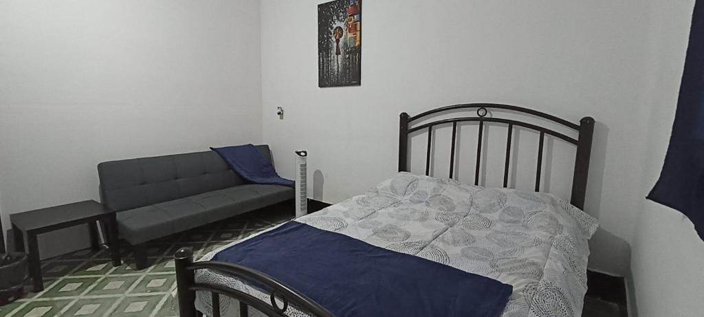 a bedroom with a bed and a couch at Hostal Casa Azul, sencilla in Orizaba