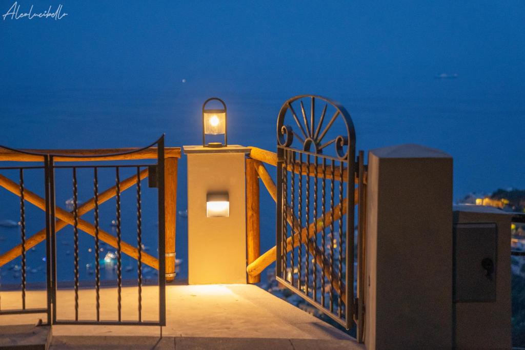 a gate with a light on a balcony at night at L'Acquolella in Positano