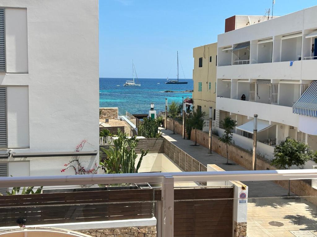 a view of the ocean from the balcony of a building at Bilocale vista mare Es Pujols in Es Pujols