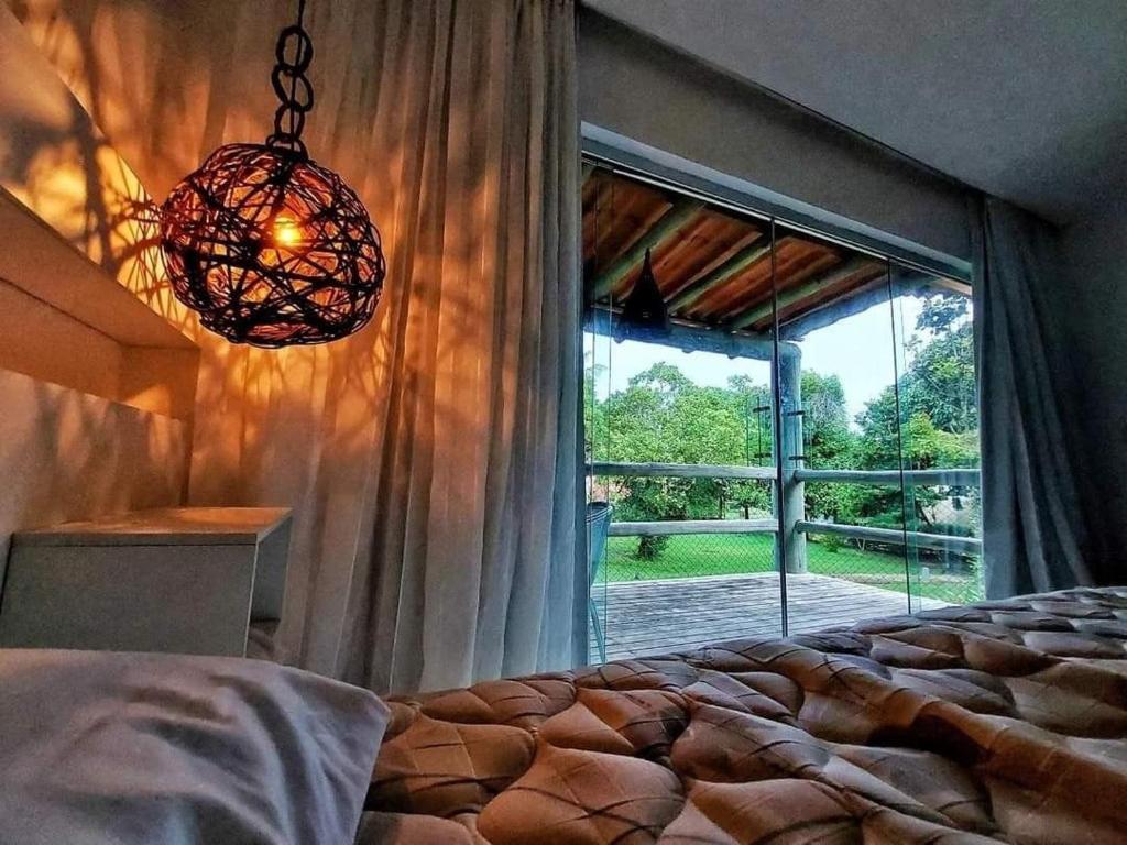 um quarto com uma cama e uma grande janela em Bangalô Villas do Pratagy 1 Dormitório e Varanda em Maceió