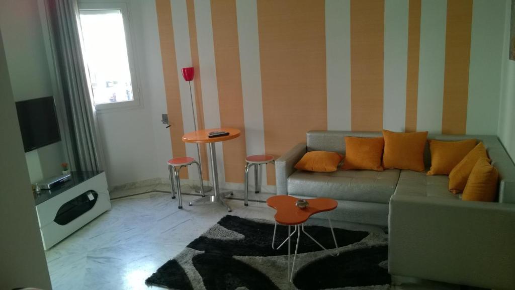 uma sala de estar com um sofá e uma mesa em Résidence Ghozlane em Tunes