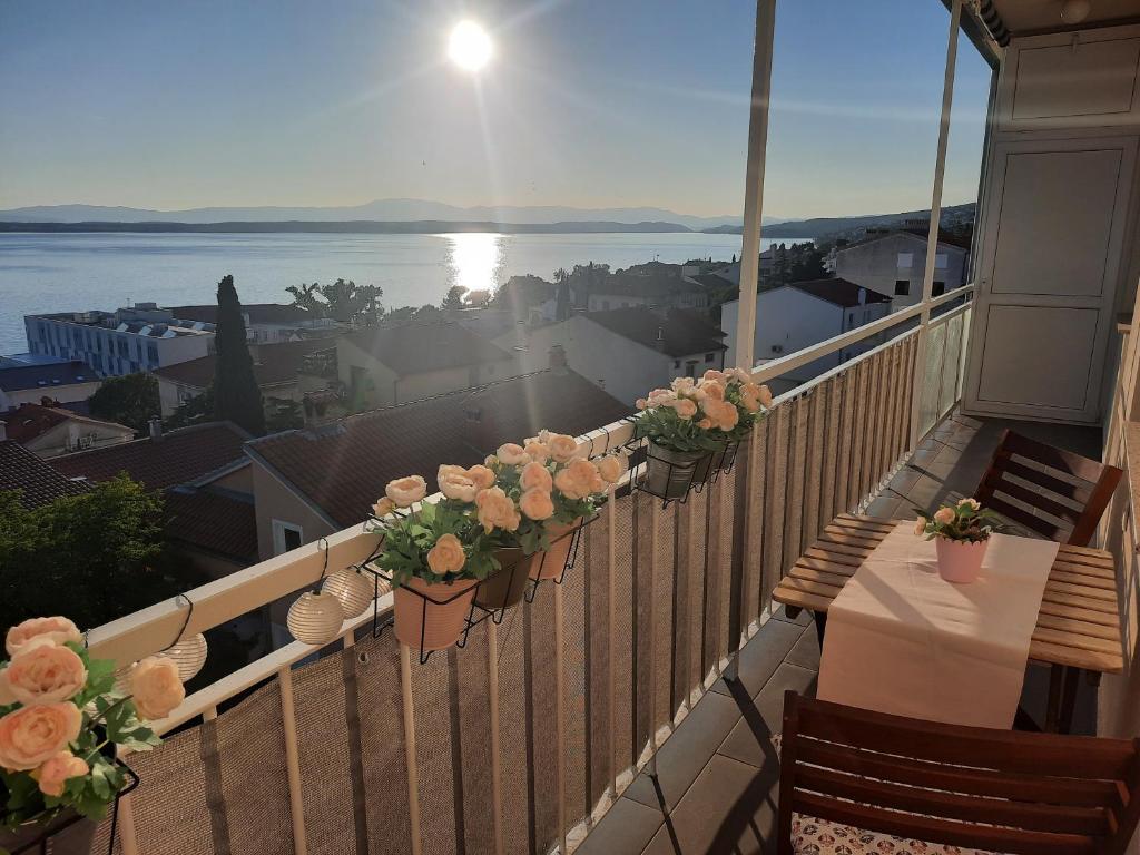 einen Balkon mit einem Tisch und Blumen darauf in der Unterkunft Top view in Crikvenica