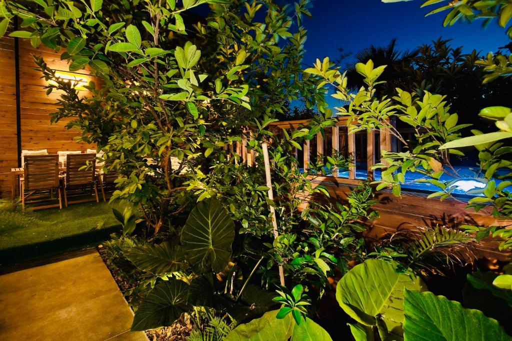 einen Garten mit Bäumen und einem Pool im Hintergrund in der Unterkunft אדמת הארץ - Admat Haaretz in H̱azon