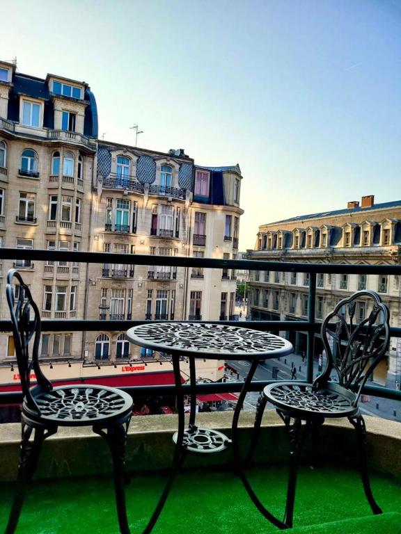 une table et deux chaises assises au-dessus du balcon dans l'établissement Appartement standing centre Gare LILLE FLANDRES, à Lille