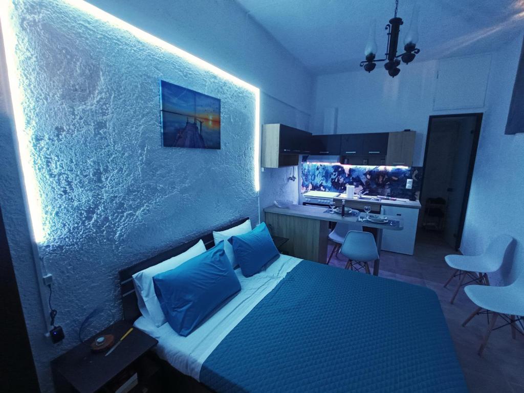 a bedroom with a bed with blue pillows at AkoumiaStudio in Akoumia