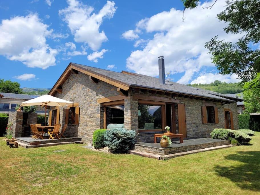 een klein stenen huis met een veranda en een patio bij El Xalet de la Padrille in Enveitg