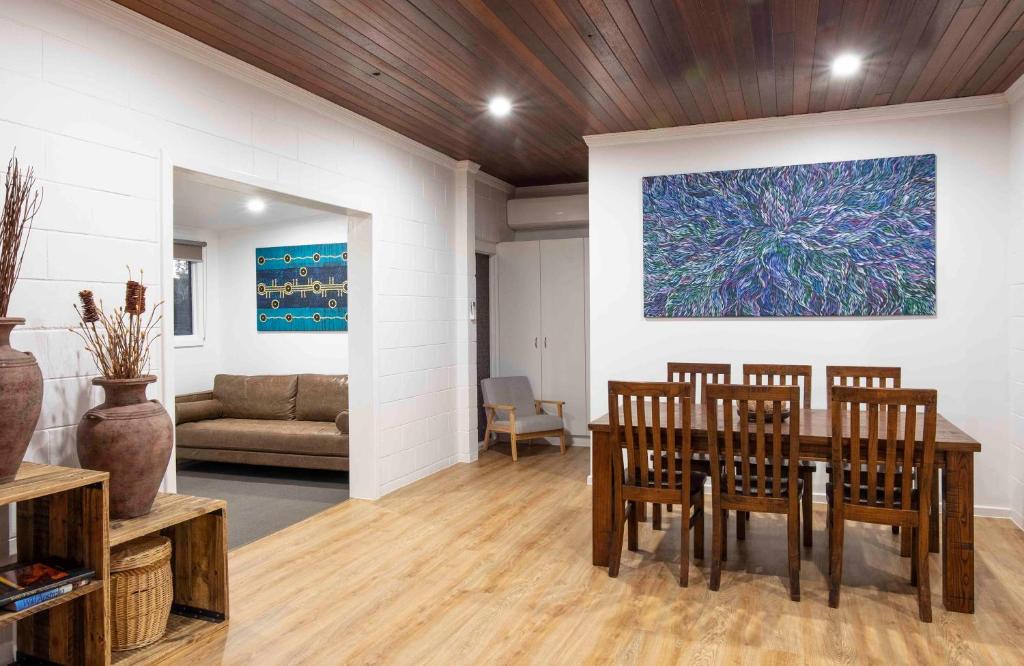 a dining room with a table and chairs and a painting at 4 Bedrooms, 2 Bathrooms in Alice Springs in Alice Springs