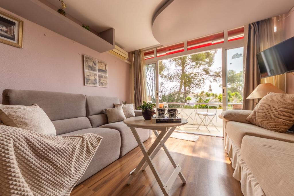 ein Wohnzimmer mit Sofa und Tisch in der Unterkunft Acogedor Bungalow Park Florimar in Tarragona