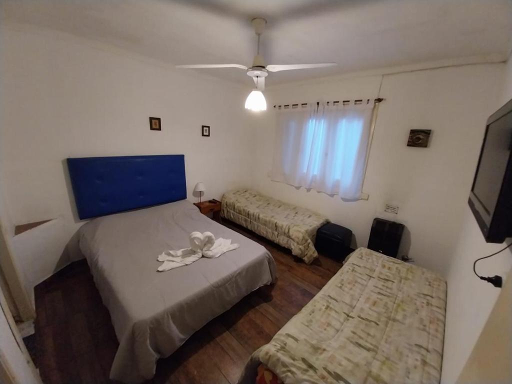 Habitación pequeña con 2 camas y TV. en Hotel Florencia en Necochea