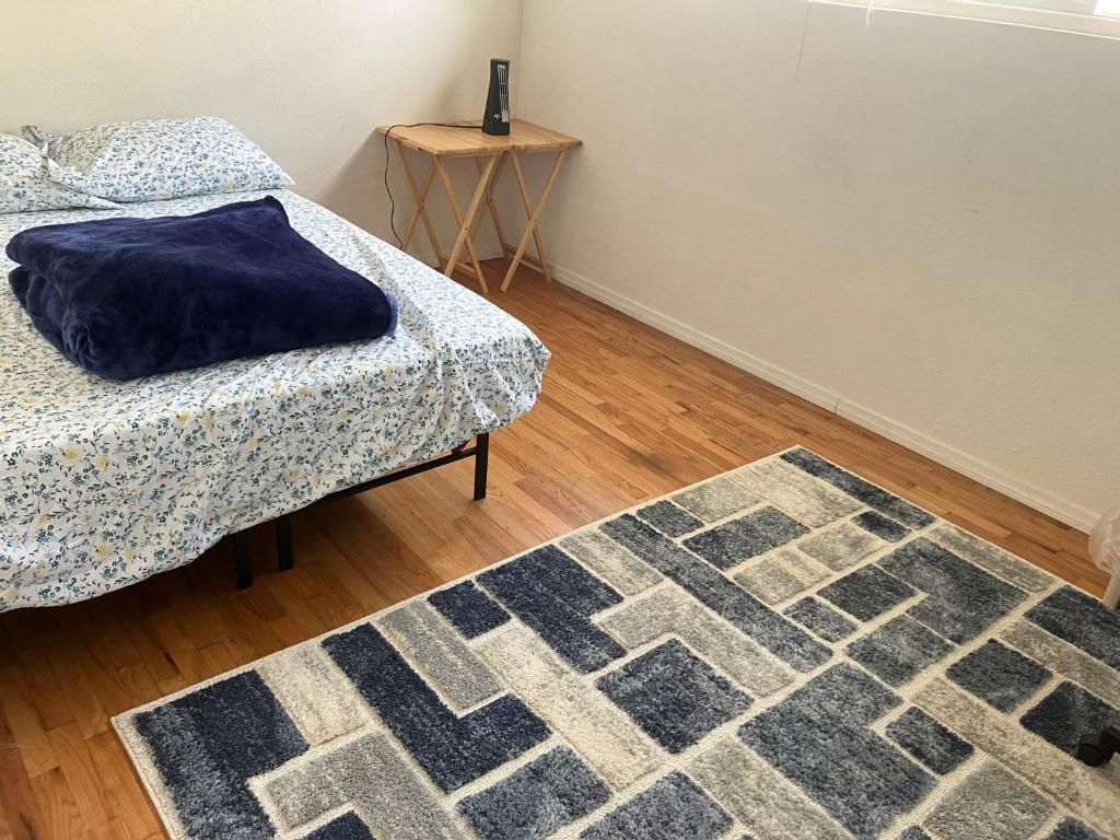 a room with a bed and a rug and a table at Nearby Beach House in El Segundo